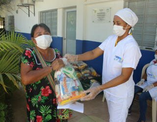 Paikalliset kouluviranomaiset ja WFP jakavat kotiin vietäviä annoksia (Take-Home Rations, THR) koululaisille ja heidän vanhemmilleen La Guajiran alueella Kolumbiassa. Kuva: WFP/Miller Choles