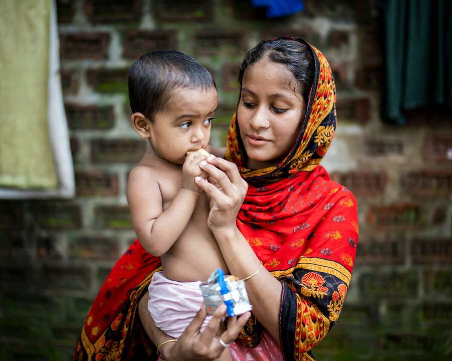 Bangladesh: Zakia and her 2-year-old daughter Shimu with fortified biscuits provided by WFP, after their home was flooded. Photo: WFP/Sayed Asif Mahmud
