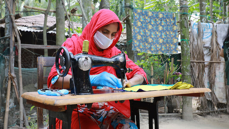 Cox's Bazarissa, Bangladeshissa, WFP teki covid-19-pandemian aikana toimeentulo-ohjelmansa kautta isäntäyhteisön ja rohingya-pakolaisten naisten kanssa naamioita, joita paikalliset viranomaiset ja humanitaariset järjestöt jakoivat ja jotka tarjosivat heille kuukausittaisen stipendin, markkinakelpoisen työkoulutuksen ja talouslukutaidon sekä stipendin yrityksen perustamista varten. WFP/Nalifa Mehelin