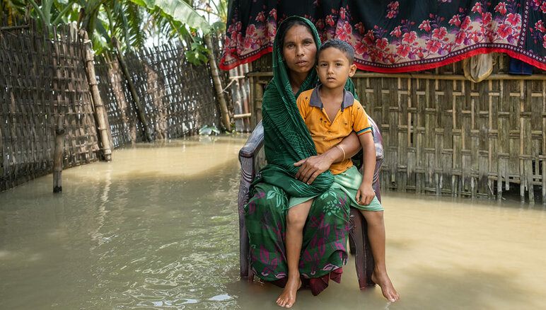 Rankat monsuunisateet tulvivat Bangladeshin pohjois- ja koillisalueille heinäkuussa 2020. Tulvavesi on tulvinut Sayeman taloon, mikä vaikeuttaa normaalia elämää. Hän ja hänen perheensä kärsivät ruokapulasta. Maailman ruokaohjelma tarjoaa raha-apua lähes 6000 perheelle Kurigramissa, jotka ovat kaikkein haavoittuvimmassa asemassa ja tarvitsevat apua. WFP/Mehedi Rahman