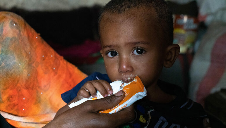 Jemen. Sultanin äiti syöttää hänelle kotona ravitsevaa maapähkinätahnaa. Hän kärsii keskivaikeasta akuutista aliravitsemuksesta. WFP:ltä saamansa lisäruoan ansiosta Sultan on alkanut saada lisää painoa ja hänellä on aiempaa enemmän energiaa. Hän tarvitsee kuitenkin edelleen hoitoa. Hänen perheensä saa myös WFP:n ruoka-apua - jauhoja, kuivattuja papuja, öljyä, sokeria ja suolaa. WFP/Mohammed Awadh.